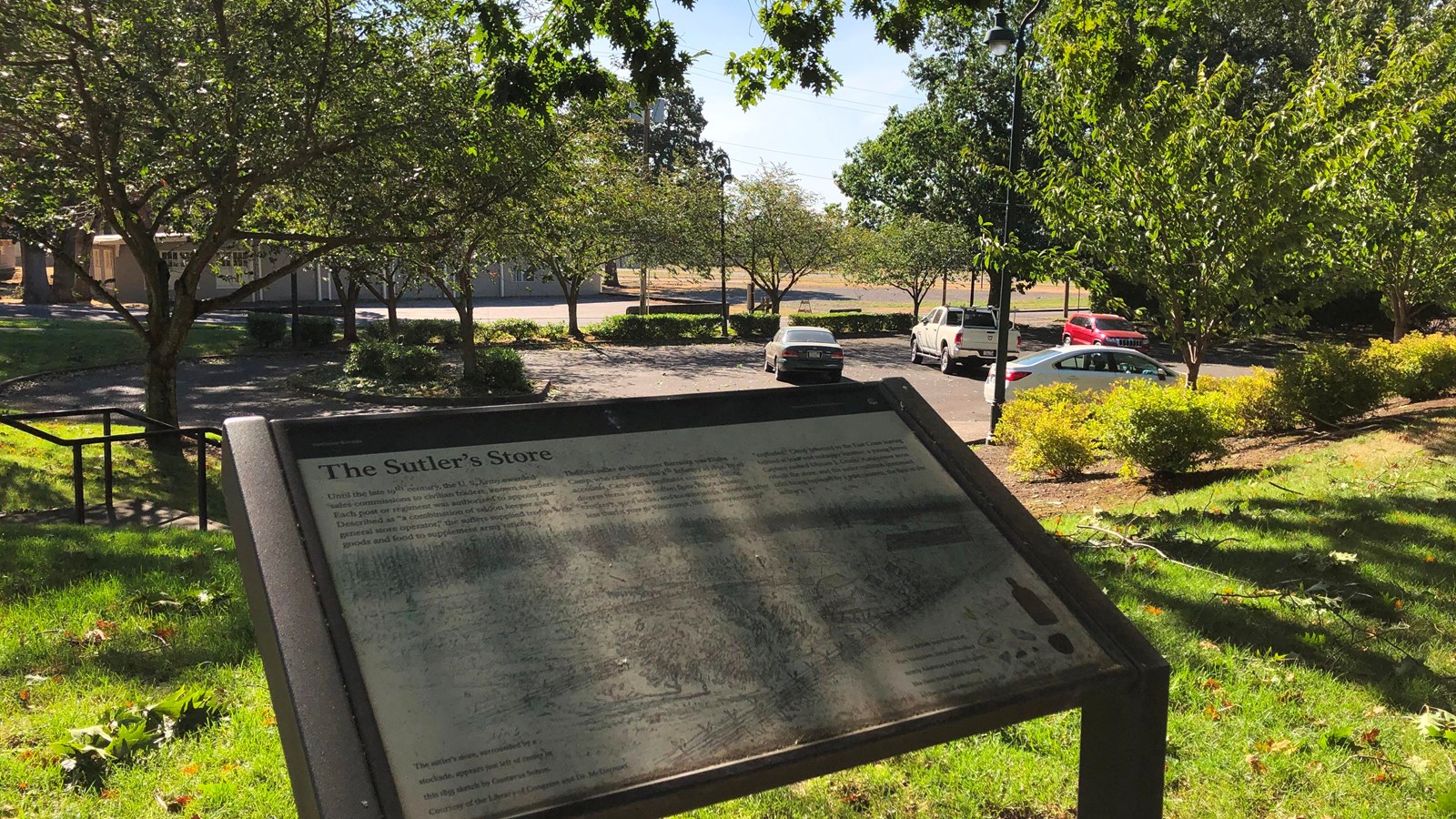 A wayside sign near a parking lot.