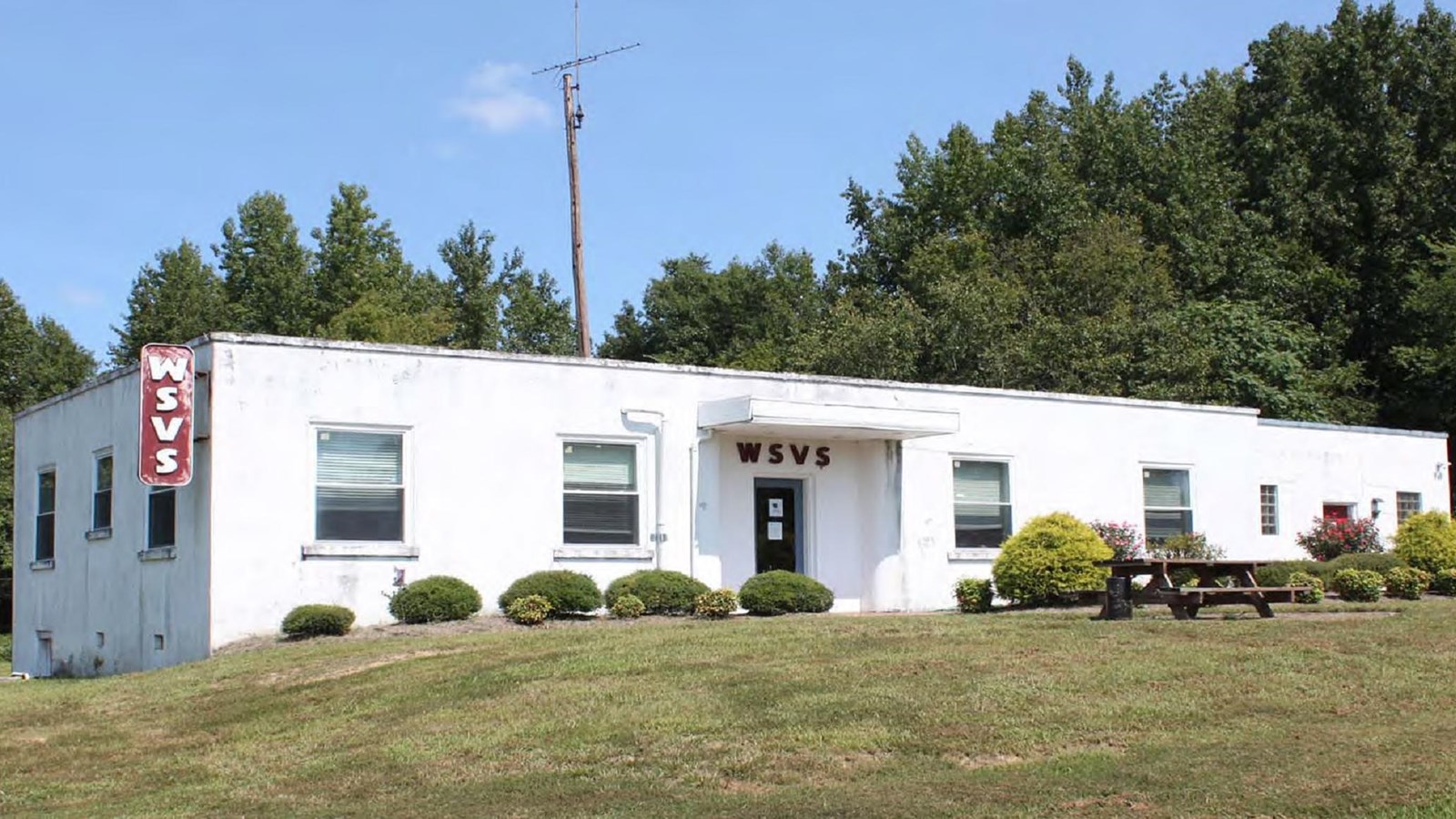 One-story white building with red WSVS sign on left side