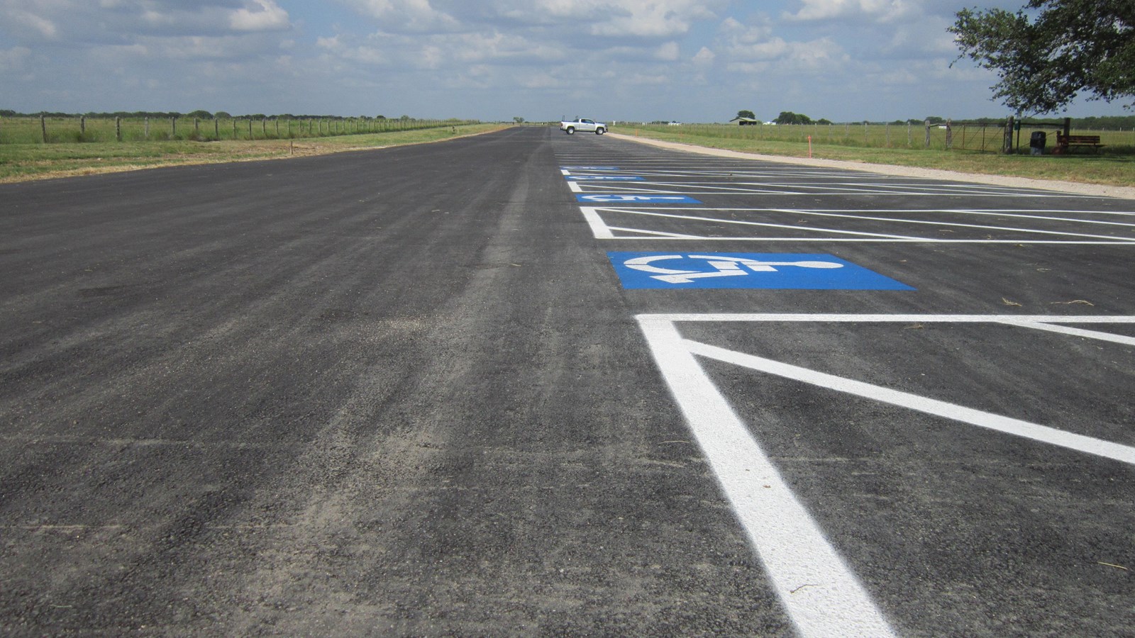 A long stretch of asphalt extends out to the horizon. White parking lines line the right edge.