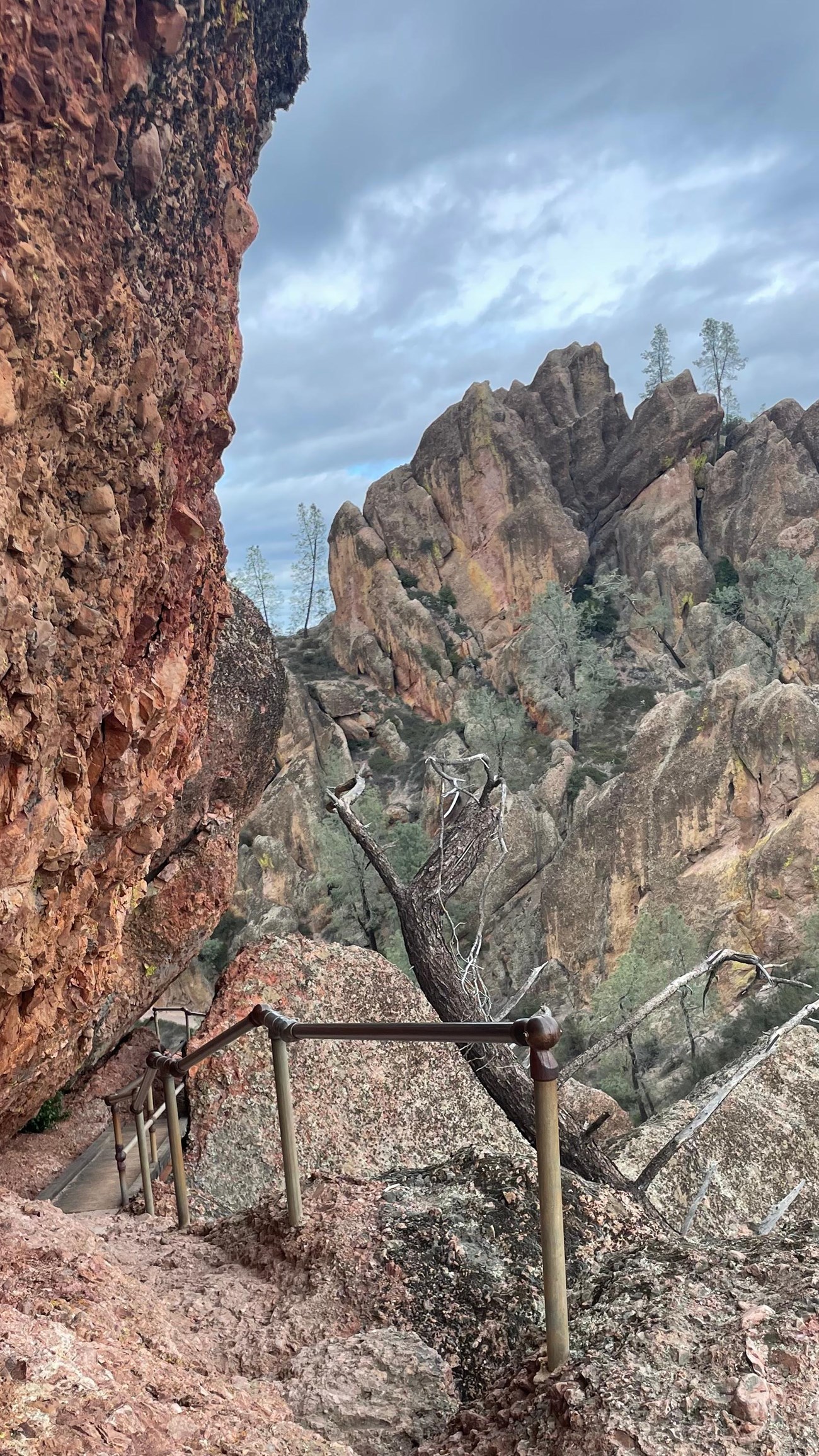 Rocky trail following the edge of a narrow steep rock canyon on stormy afternoon