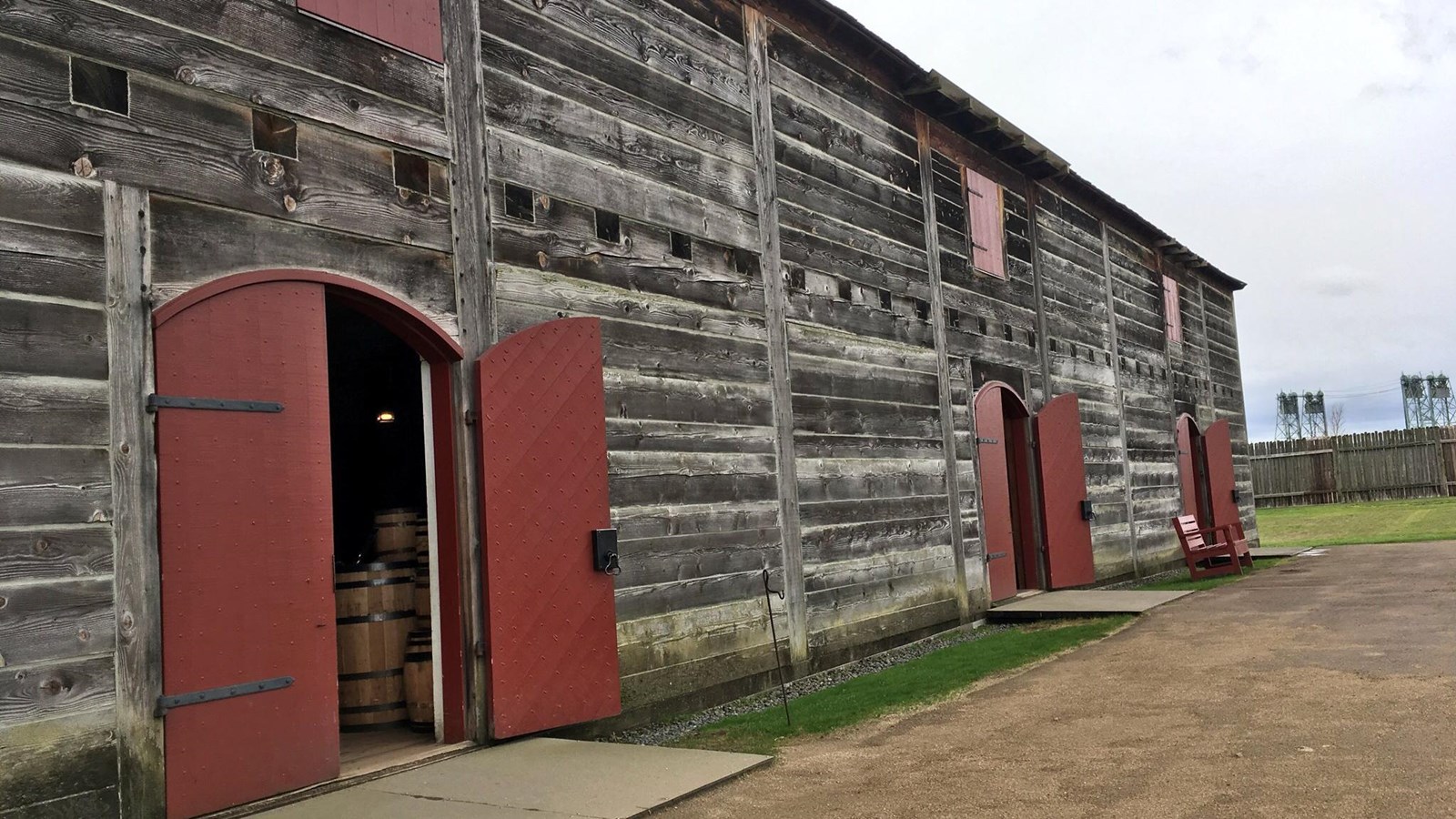 A wooden building with three doors painted red.