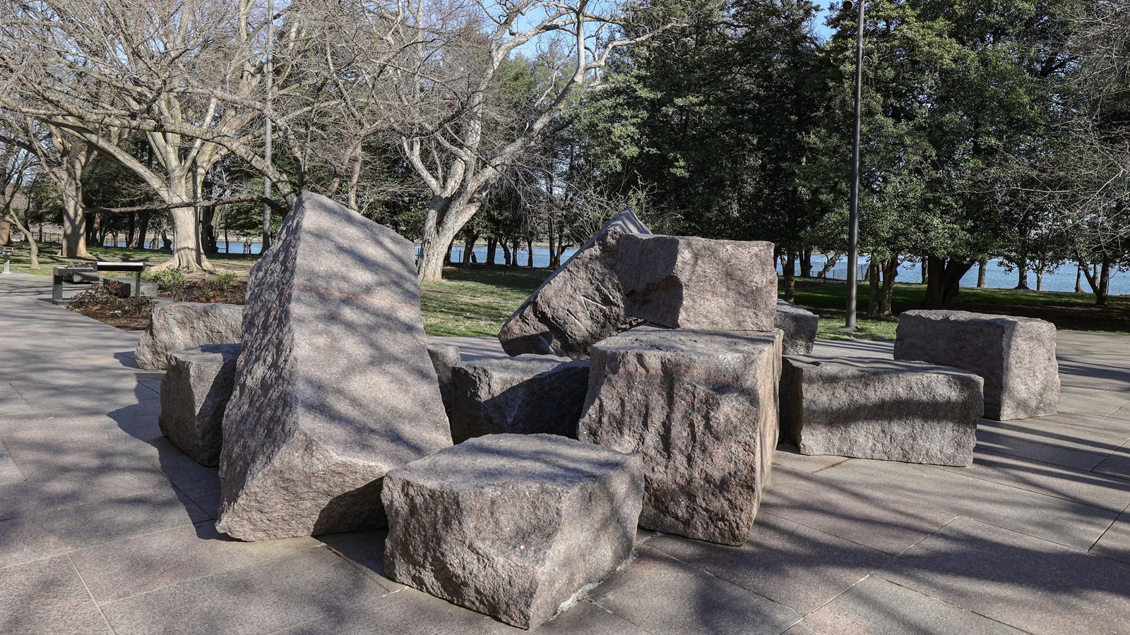 A clump of 12, large stones are stacked against each other in a chaotic fashion.