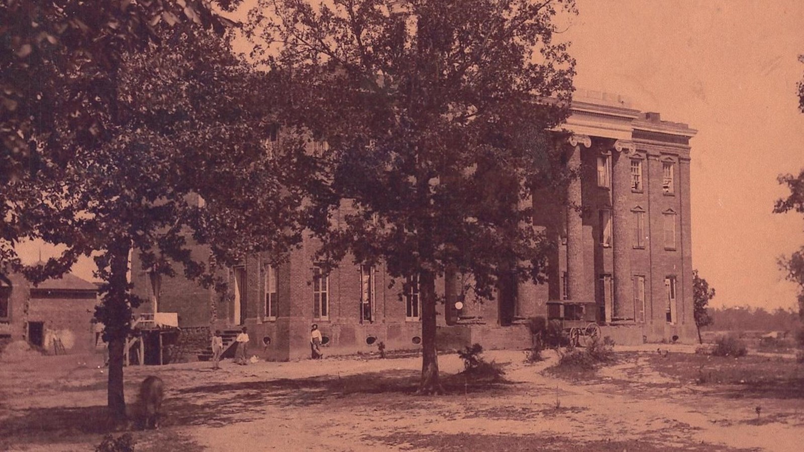 Historic photograph of large building with ionic columns. 