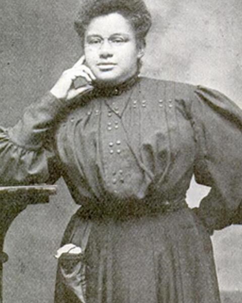 African American woman, named Ida Cummings; Her left hand on her chin & her right hand on her hip