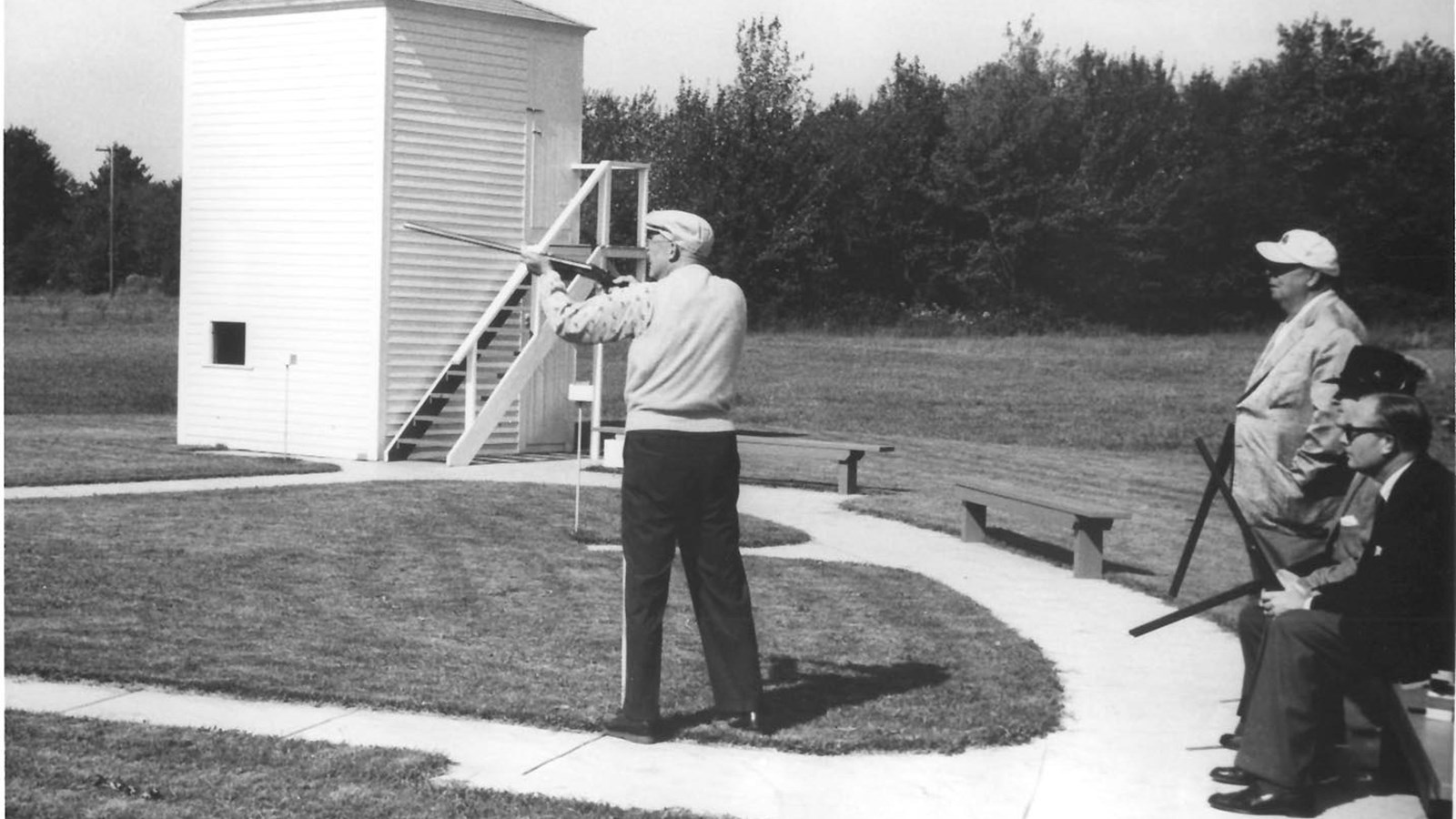 A black and white image showing General Eisenhower standing in the center of his skeet range.