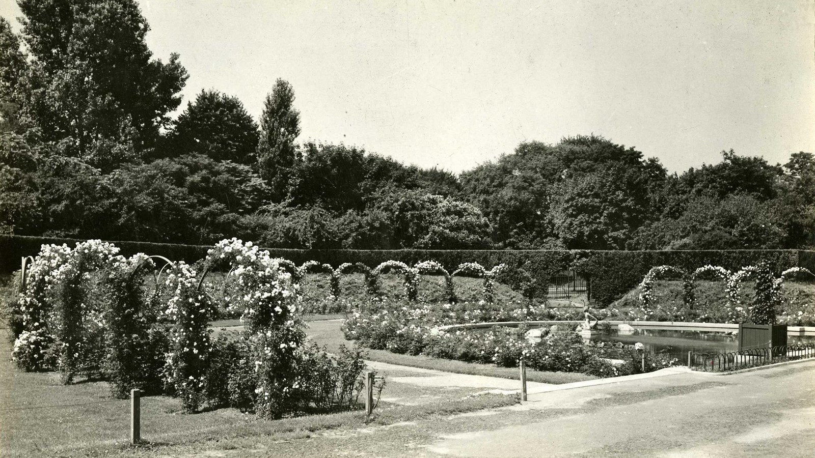 Black and white of garden area with arches and water and flower areas