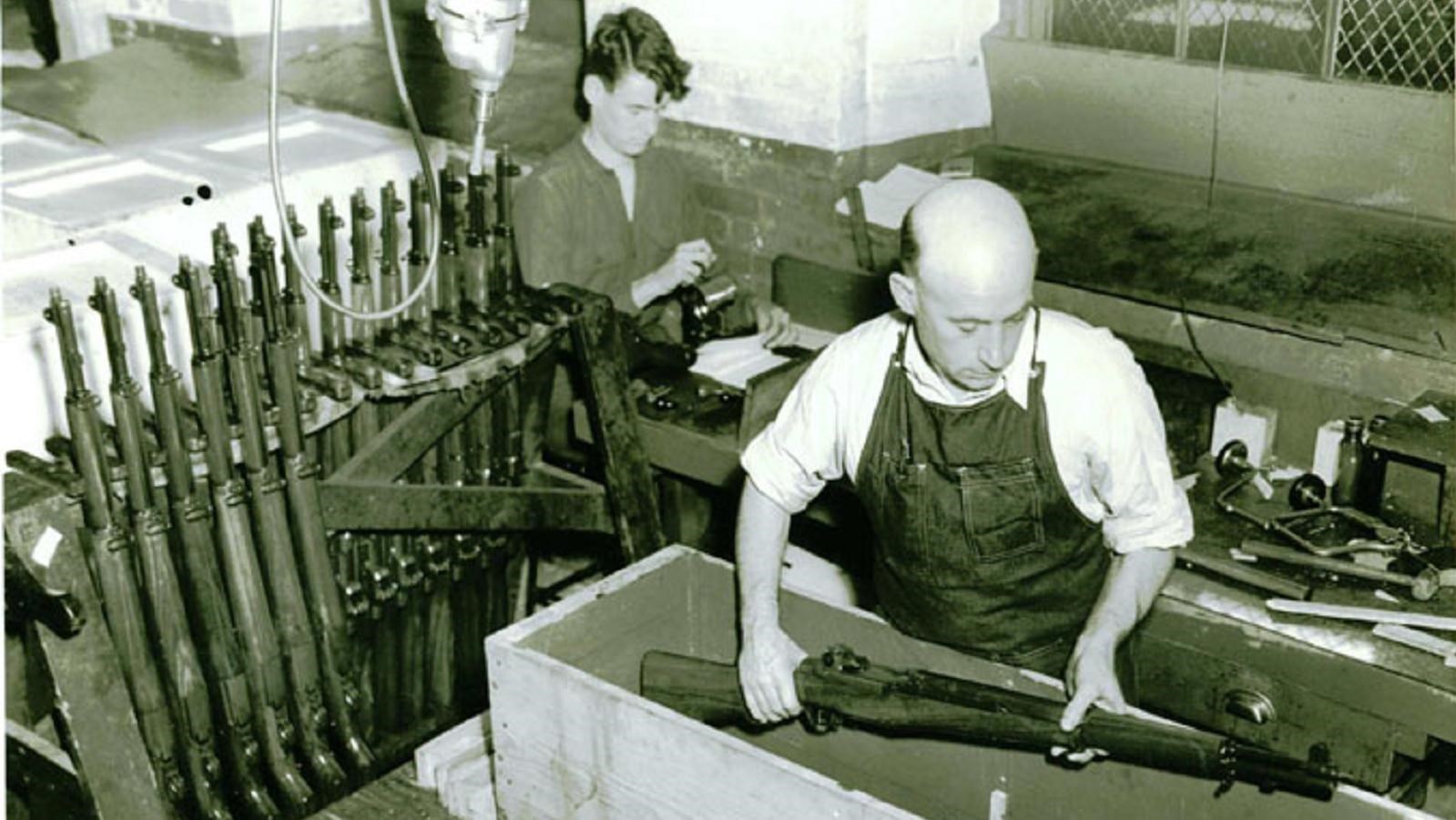 man packing rifle in crate