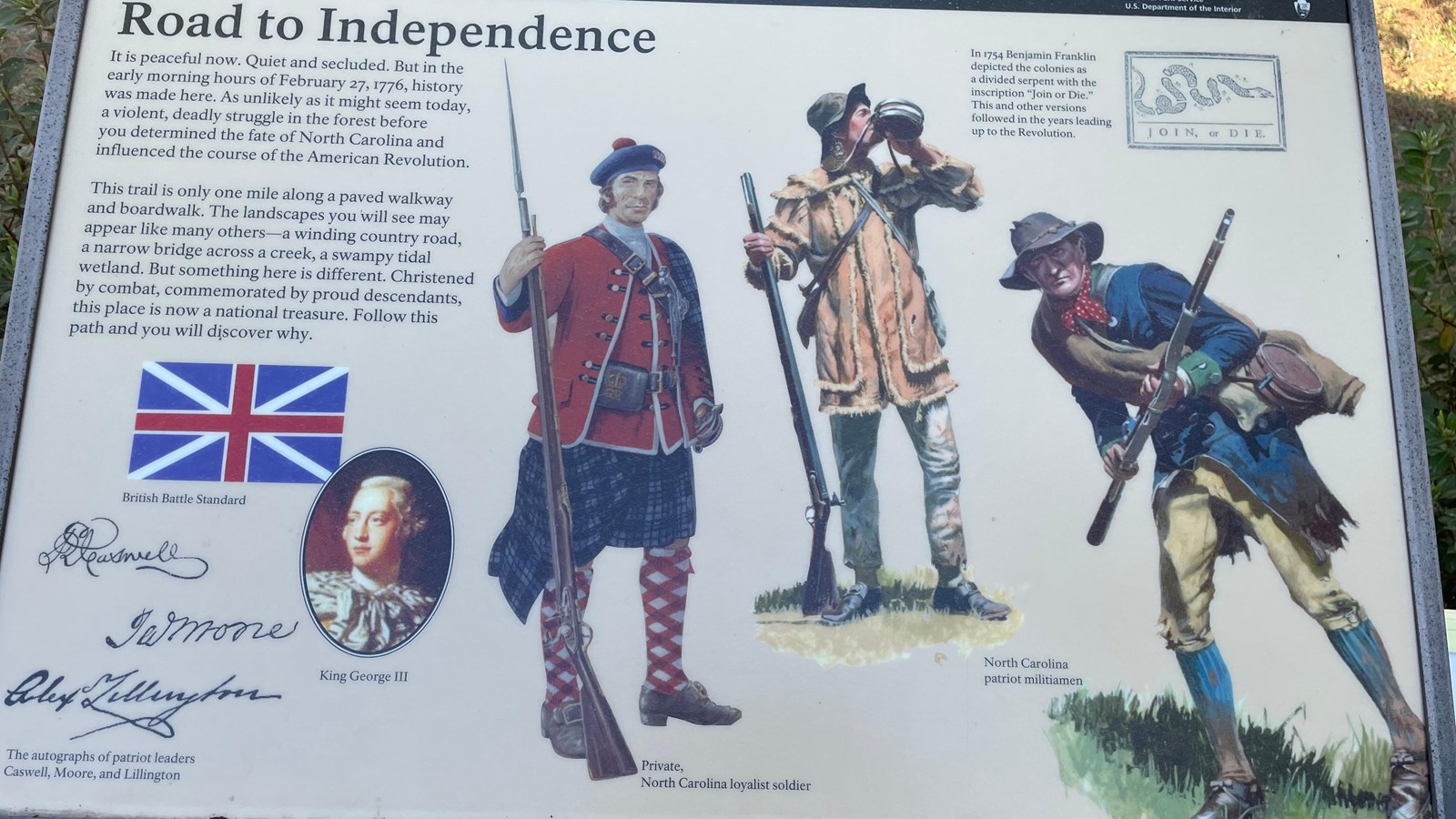 Metal 36x24 sign on the railing of the back porch of the visitor center. 