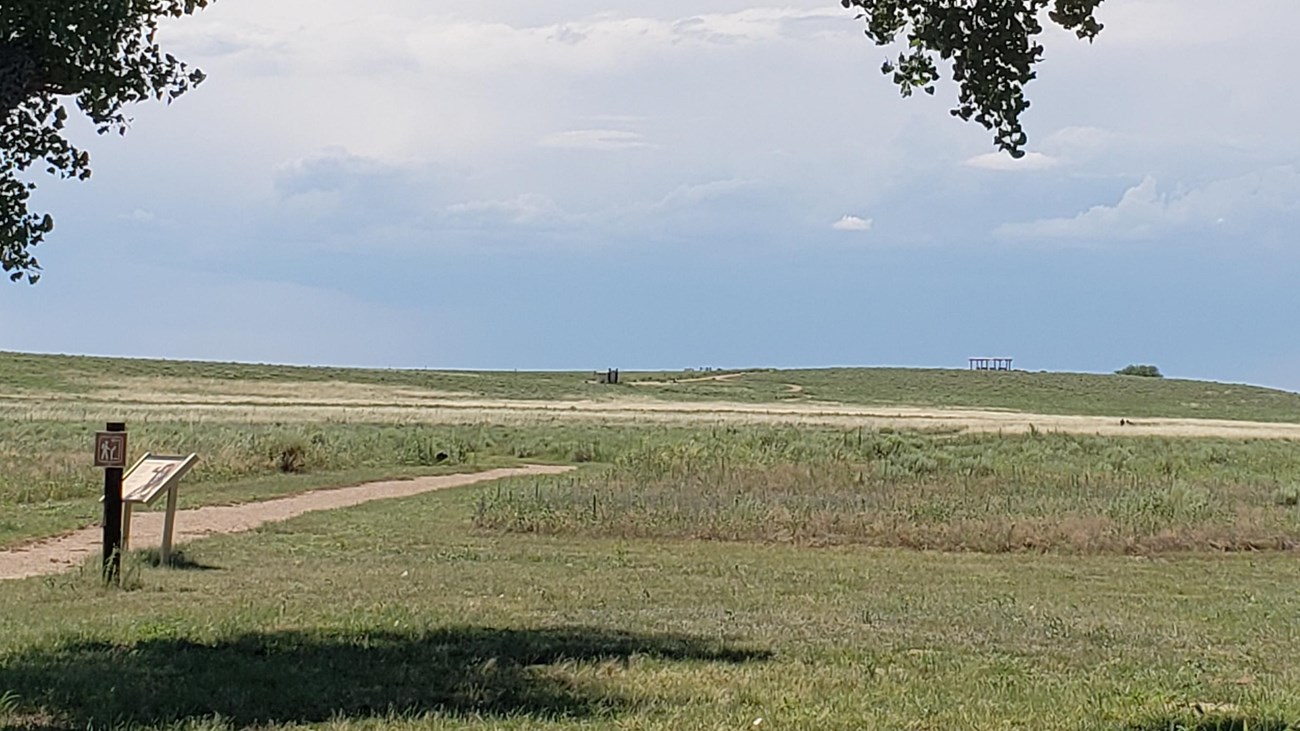 A trail leads to an overlook through a prairie landscape