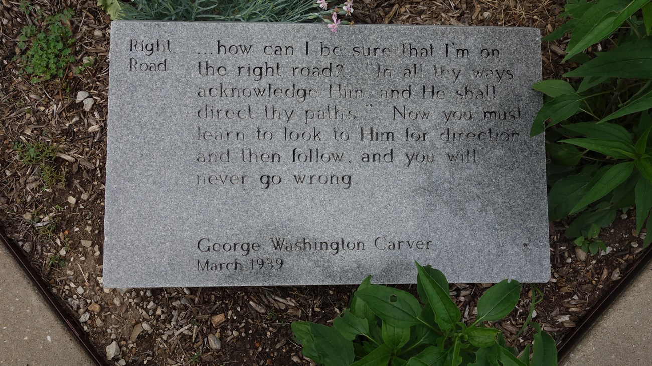 A stone granite GW Carver quote outdoor panel. 