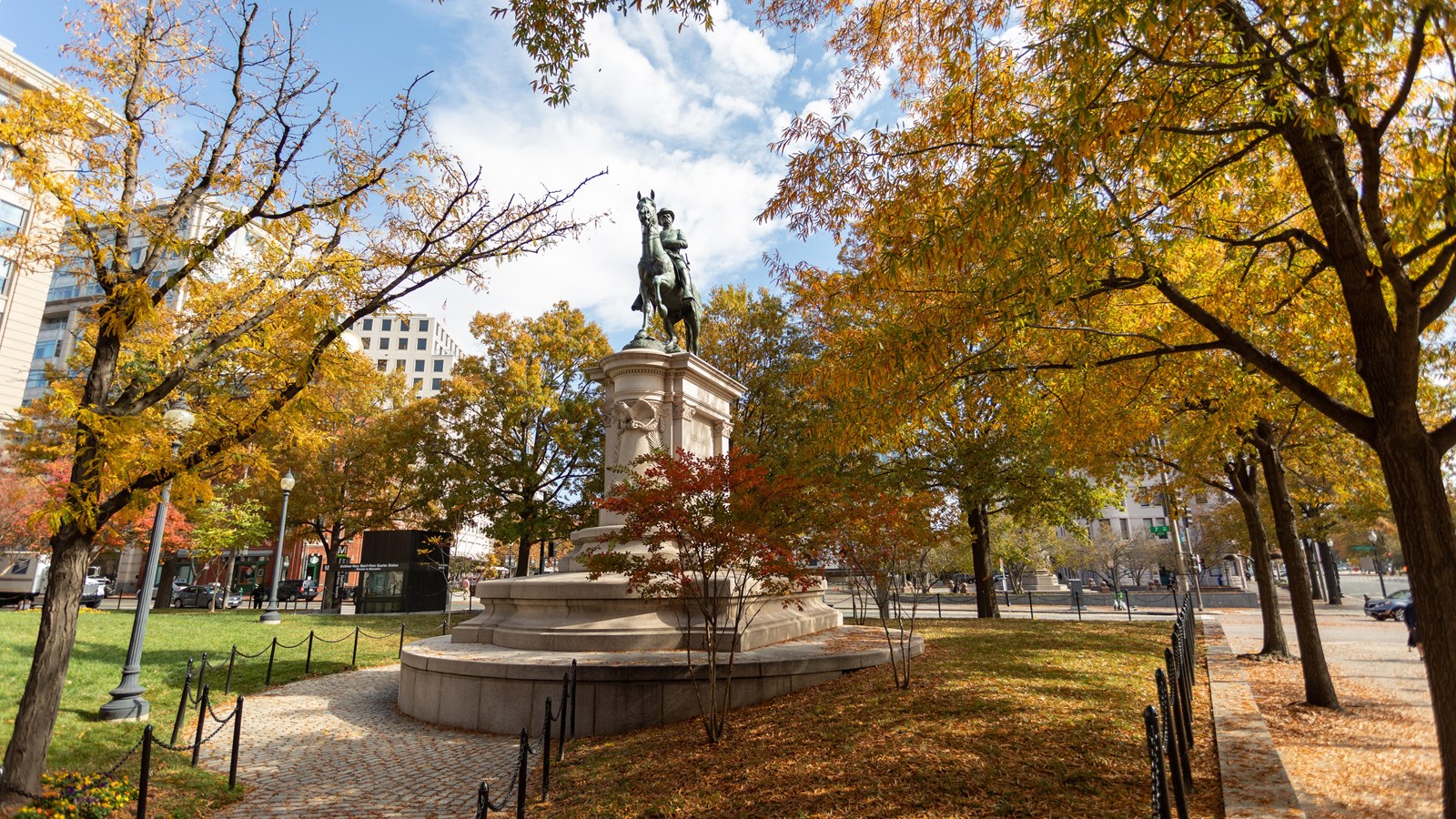 A bronze equestrian statue of a man on a horse atop a stone plinth.