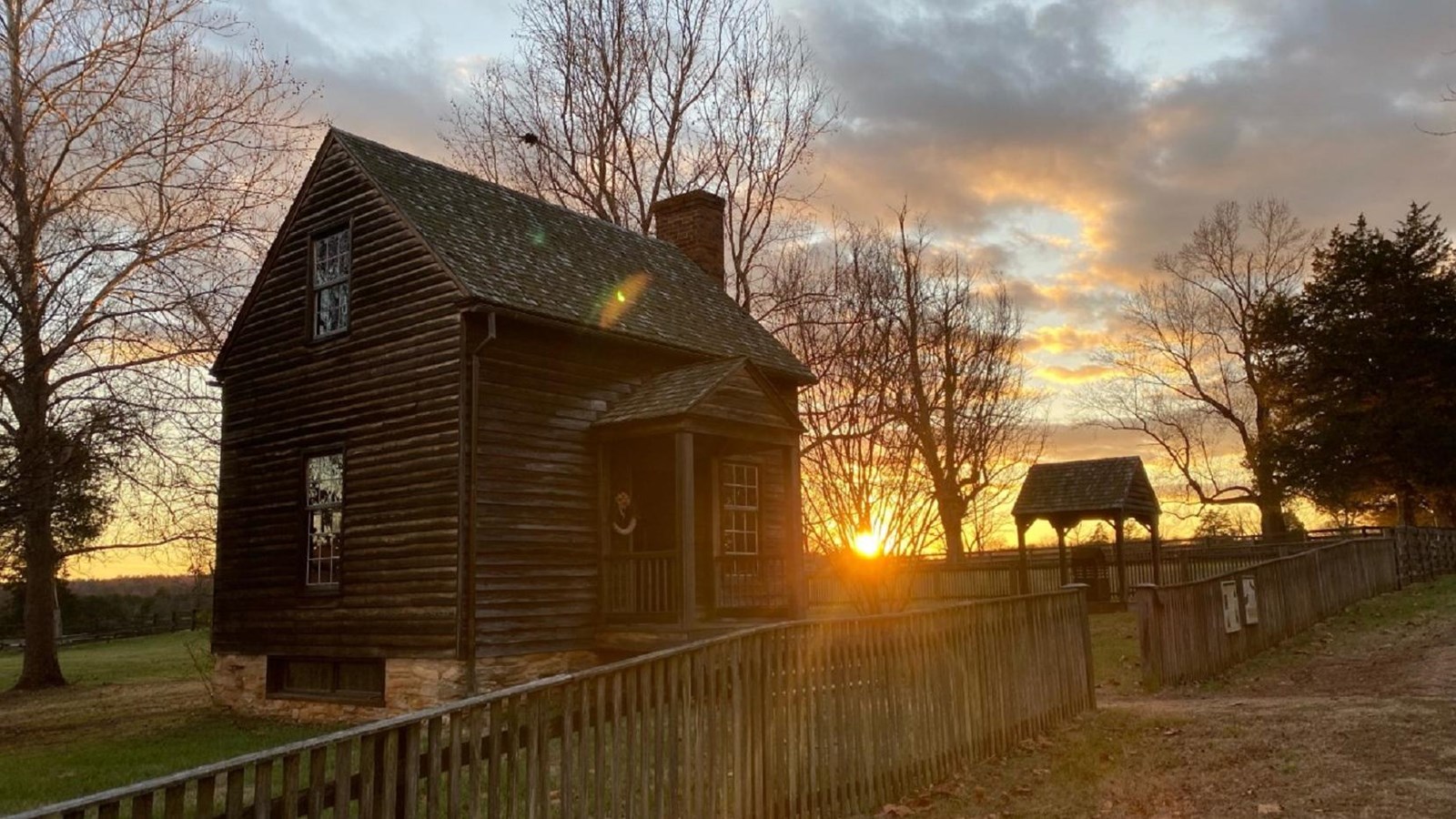 The sunsets behind the wooden Kelley/Robinson House