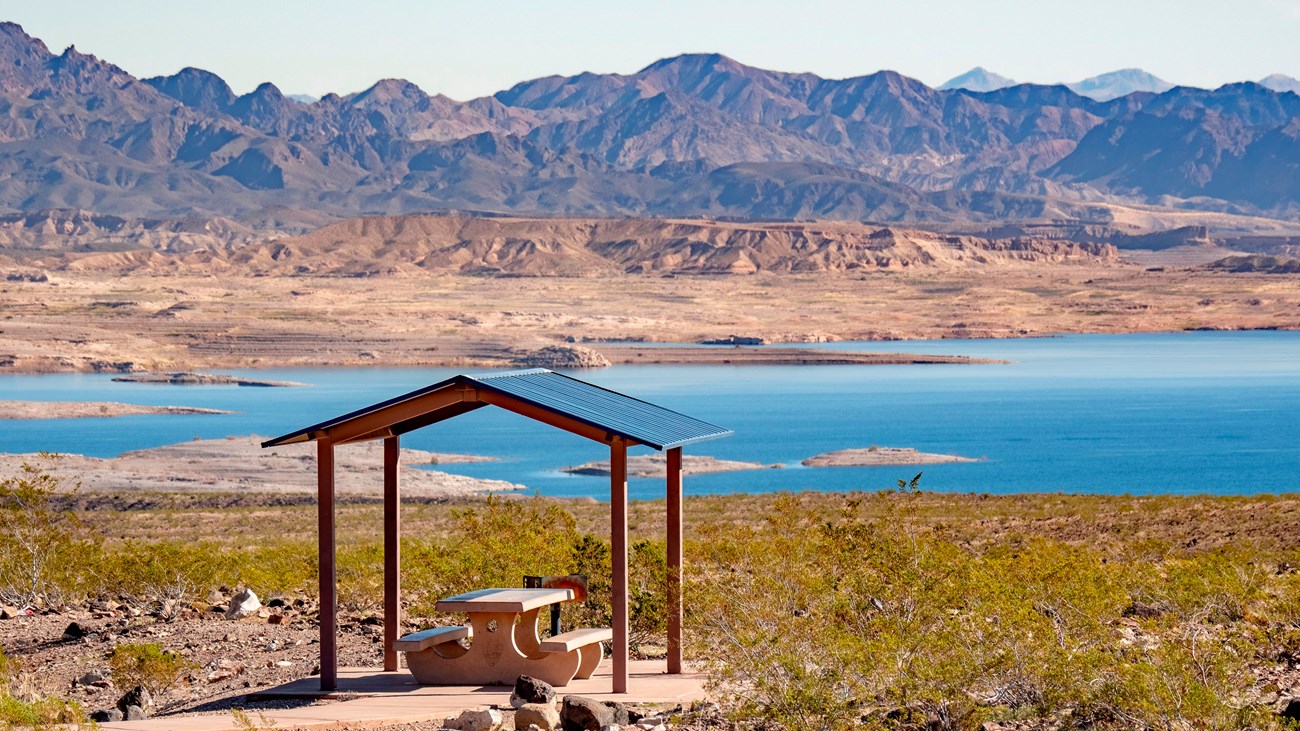 a picnic shelter with a lake in the background