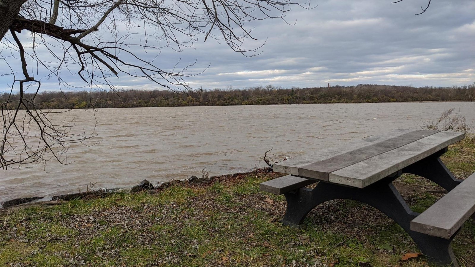 Photo of the Potomac River as seen from the Cove, a picnic table sits close to the water.