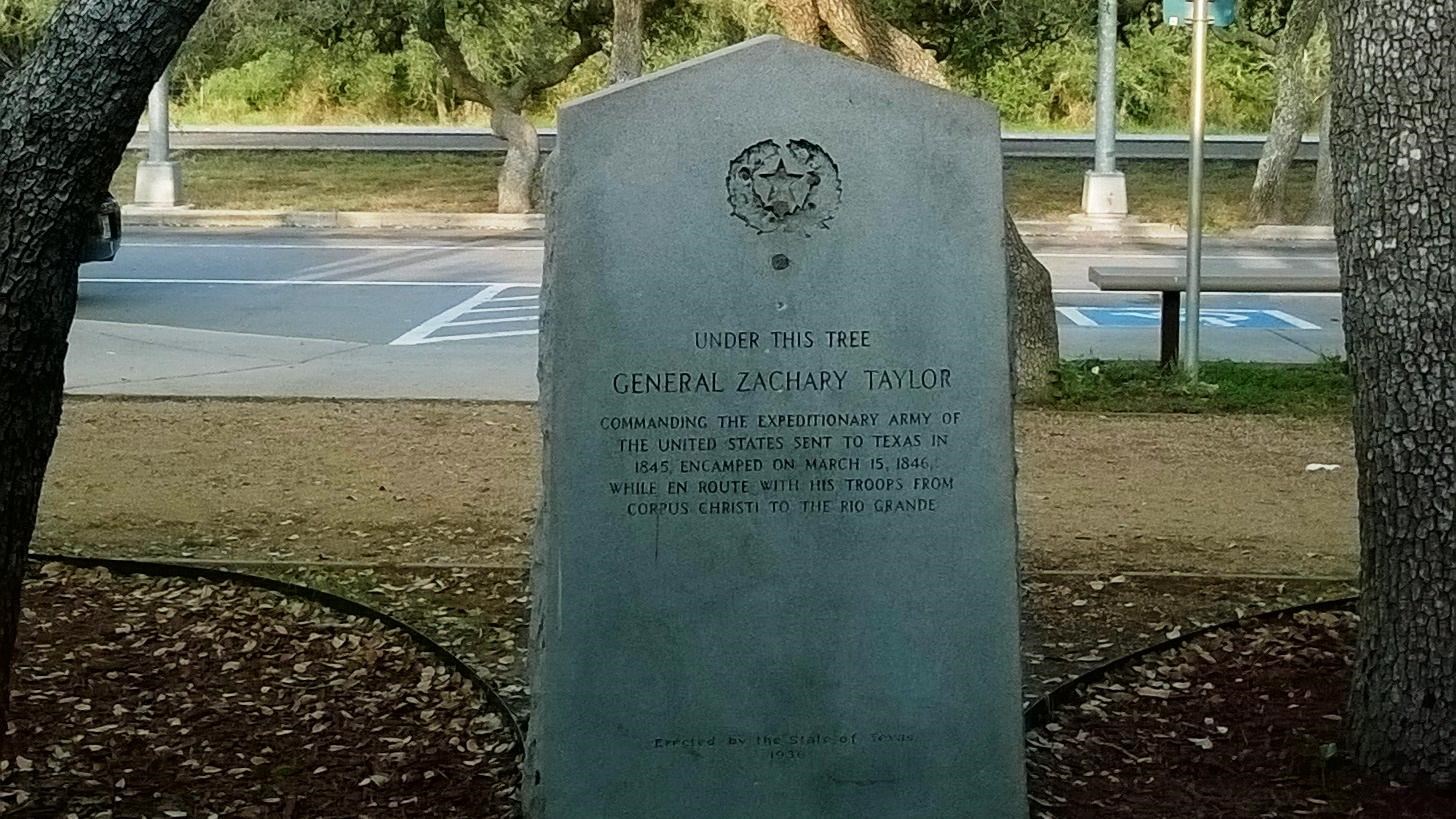 Taylor\'s Camp granite marker under trees.
