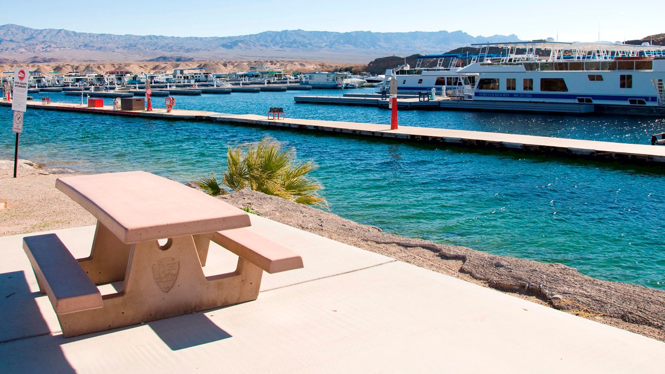 A picnic table next to a body of water