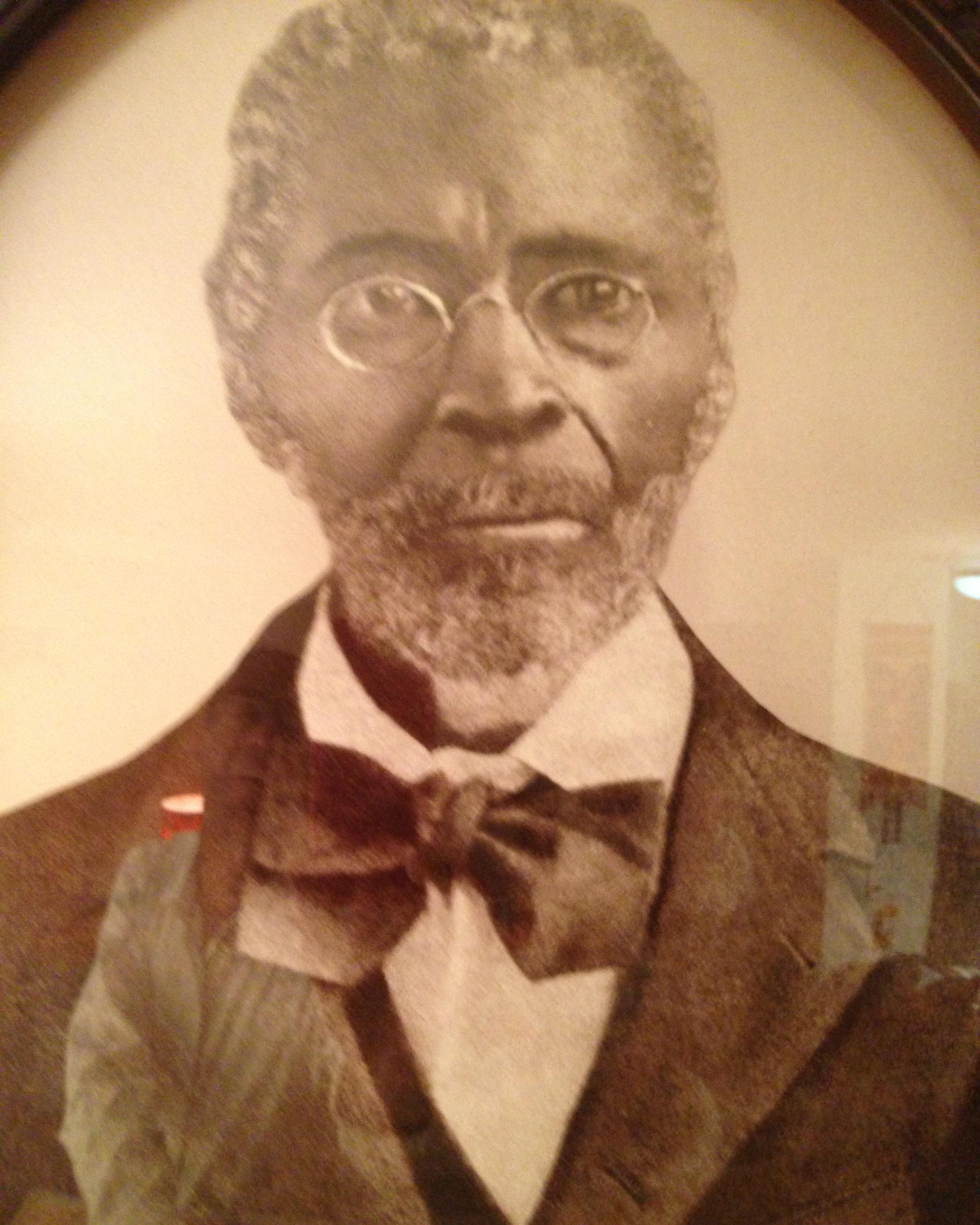 An older African American man in a suit with a bow tie
