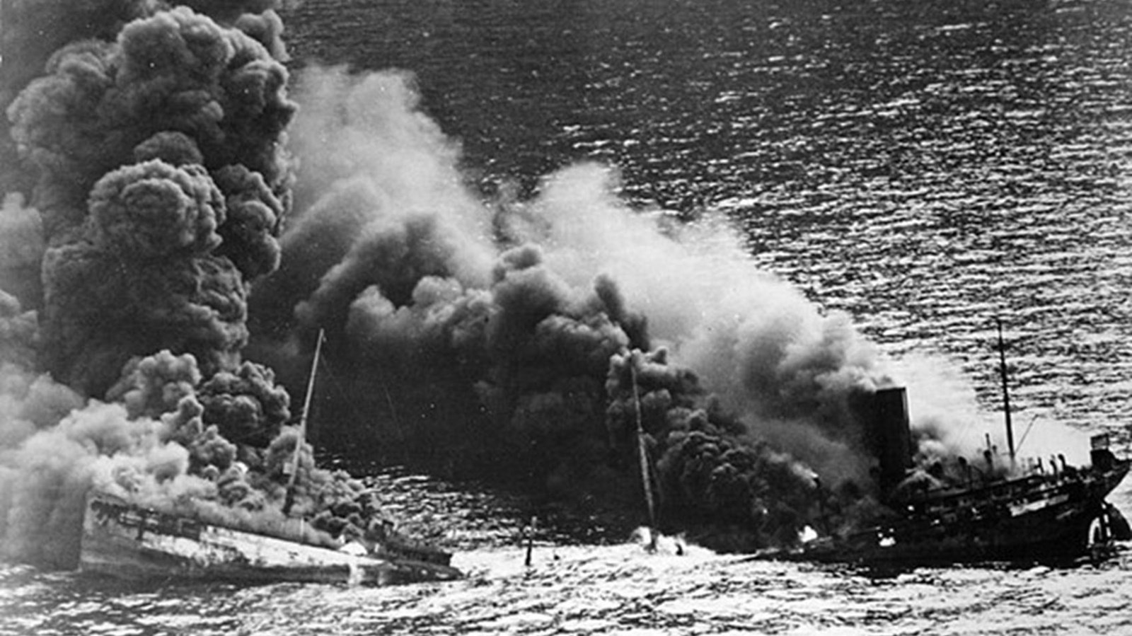 Two crumbling boats with smoke plumes overhead.