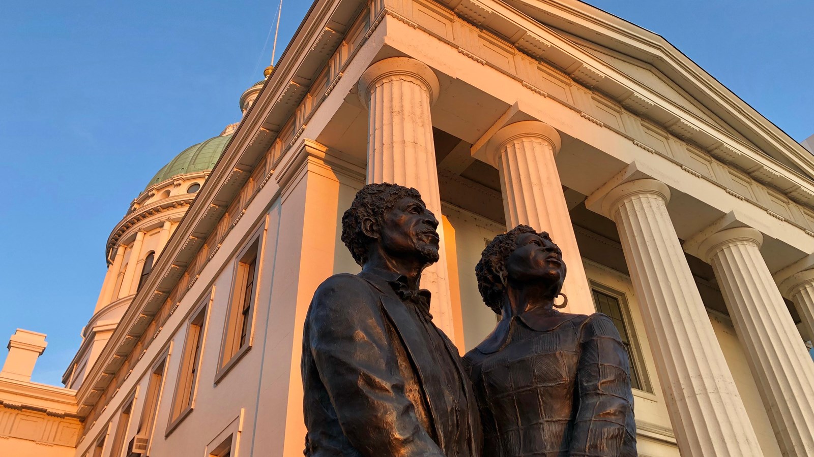 looking up at the statue of Dred & Harriet Scott with the Old Courthouse\'s classical columns behind