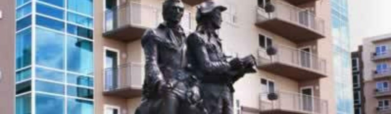 lewis and clark statue with buildings in the background