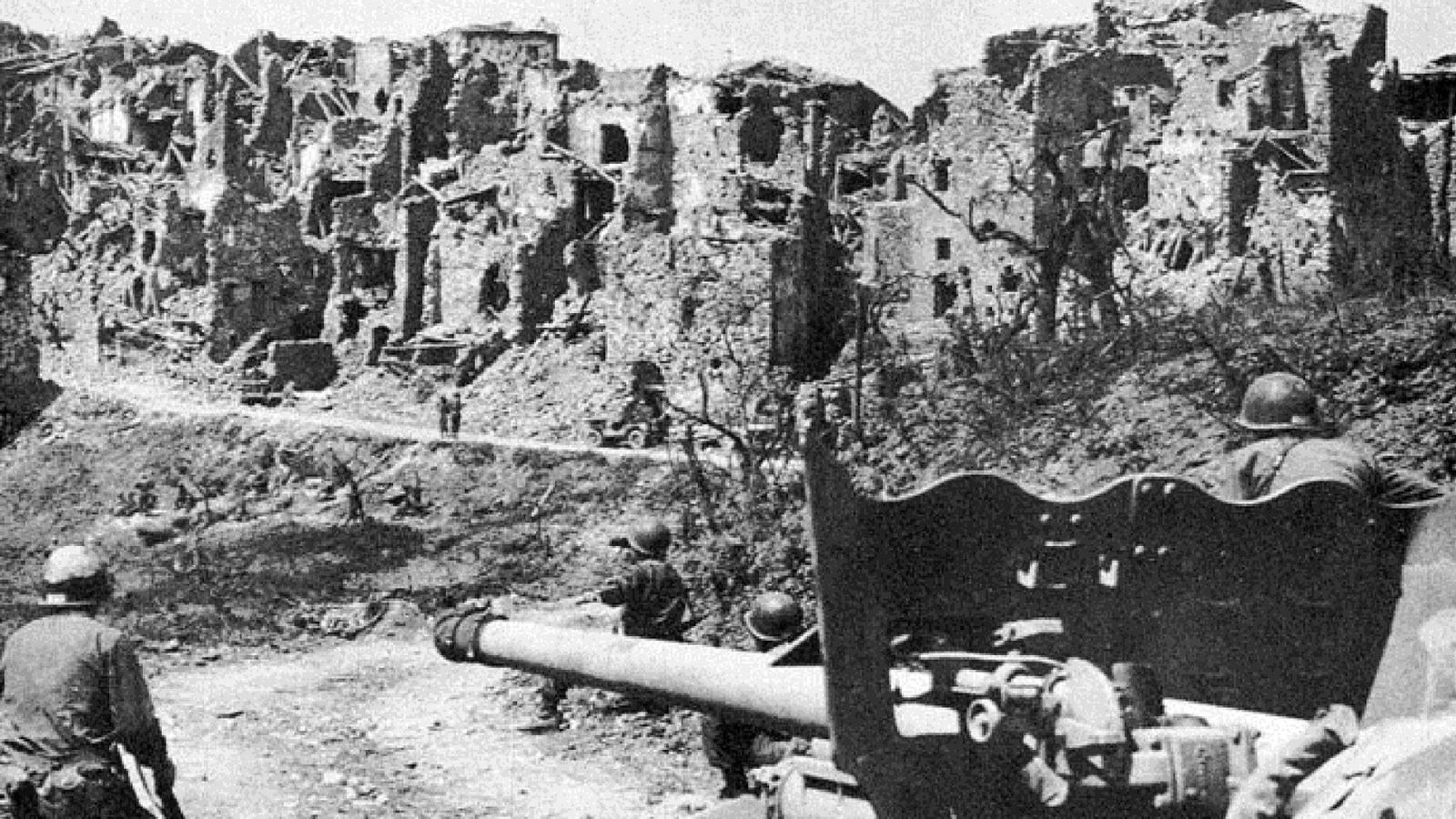 soldiers with armored vehicles and damaged buildings in the background. 