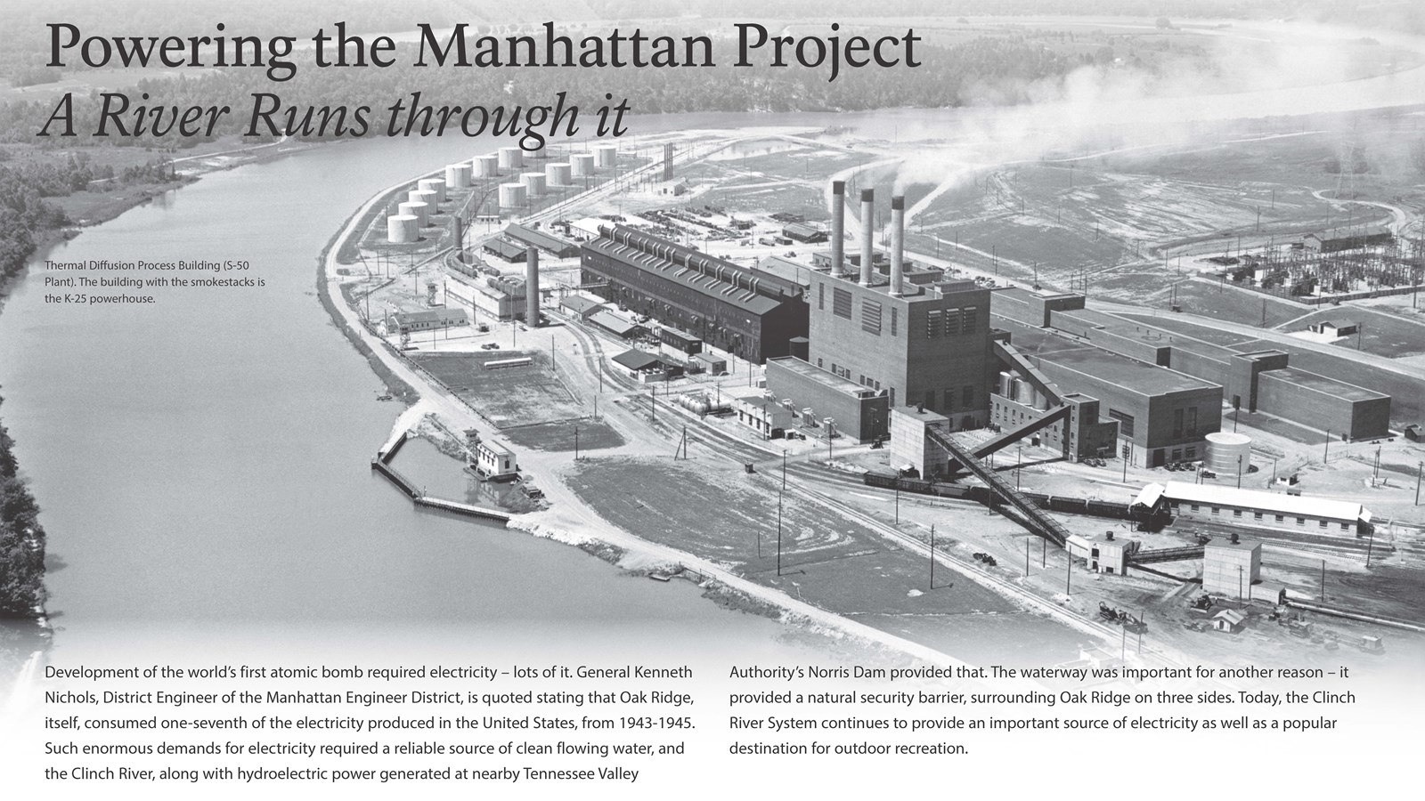 A wayside with text and an aerial photo of a large factory on a riverbank.