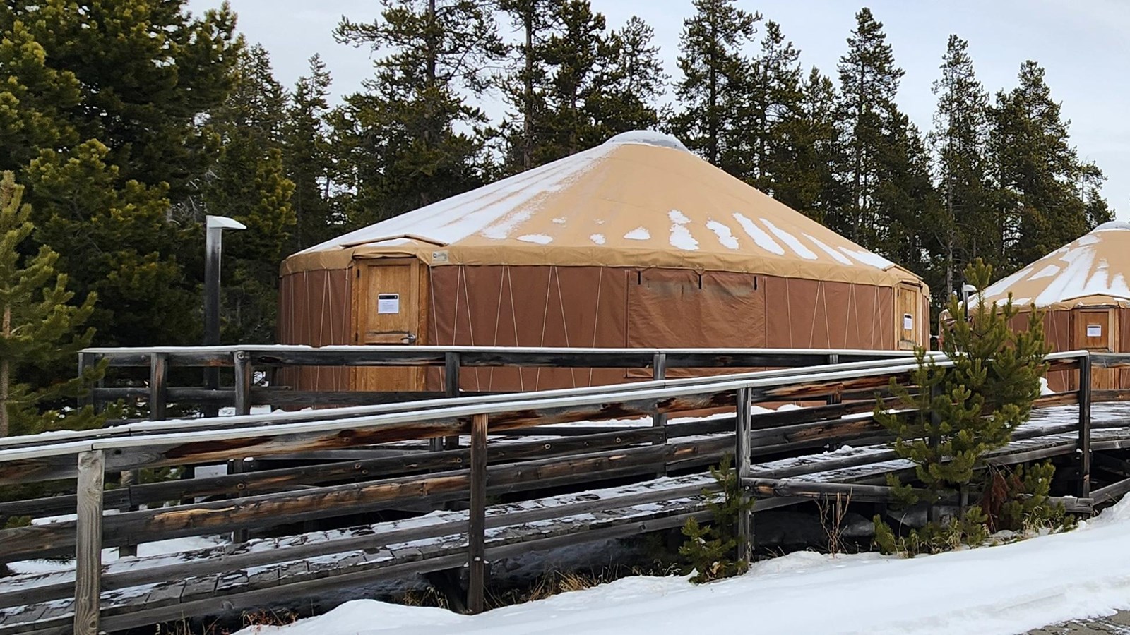 a wooden ramp with wood railings leads up to a round yurt