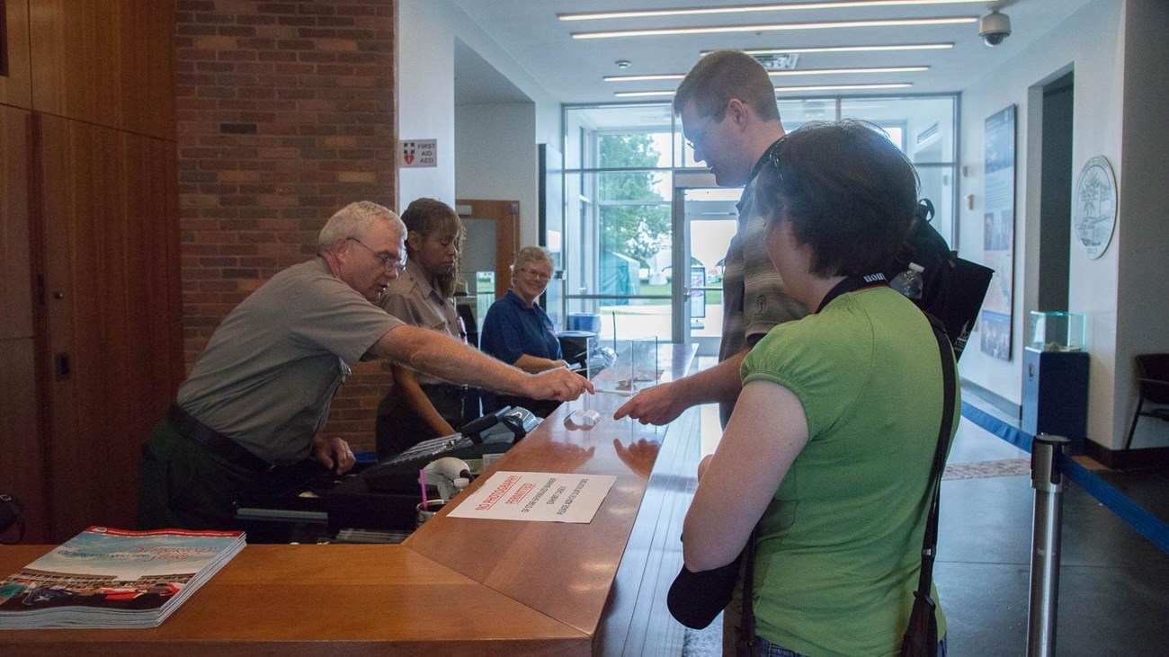 A ranger gives directions at the visitor center desk.