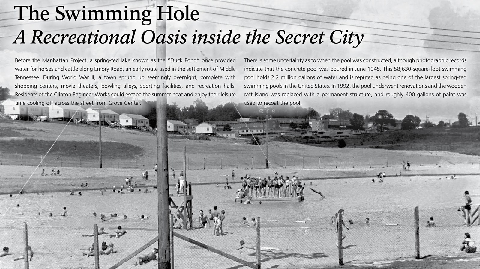 A wayside with text and many people in an outdoor public pool.