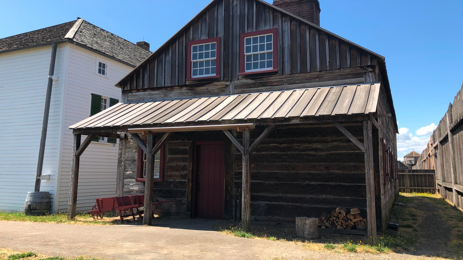 A wooden two-story building behind the Chief Factor\'s House.