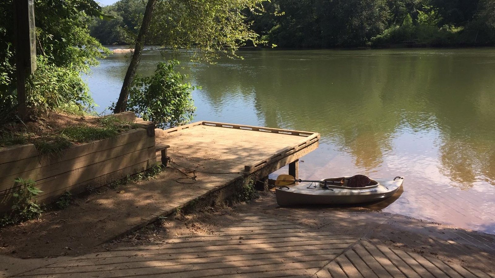 View of ramp and small deck with the river and distant wooded shoreline.