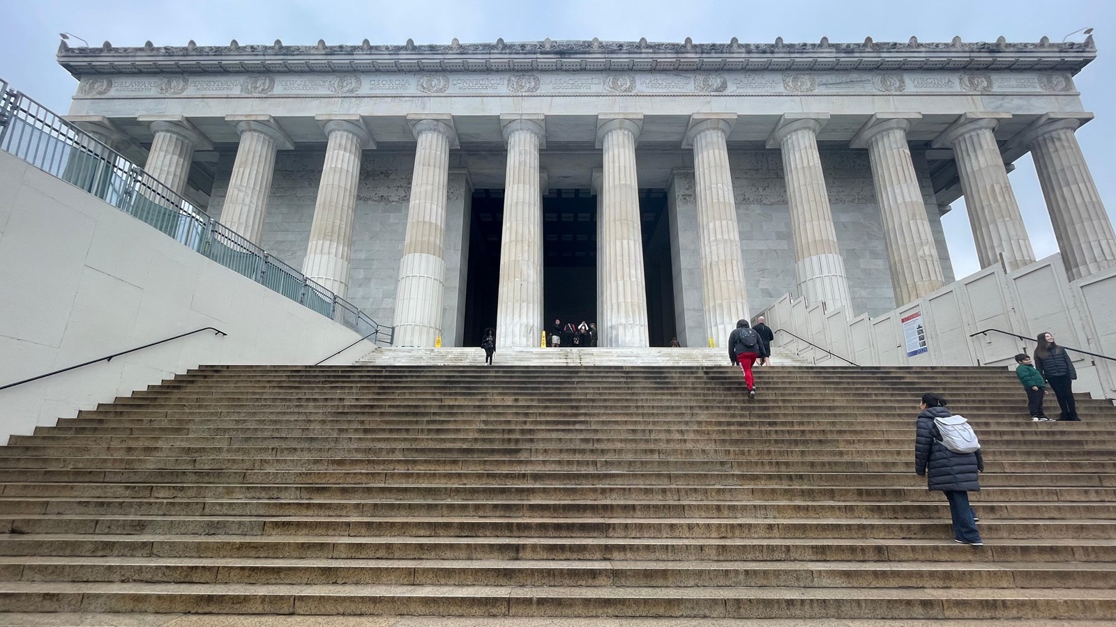 Granite steps lead up to a colonnaded white building