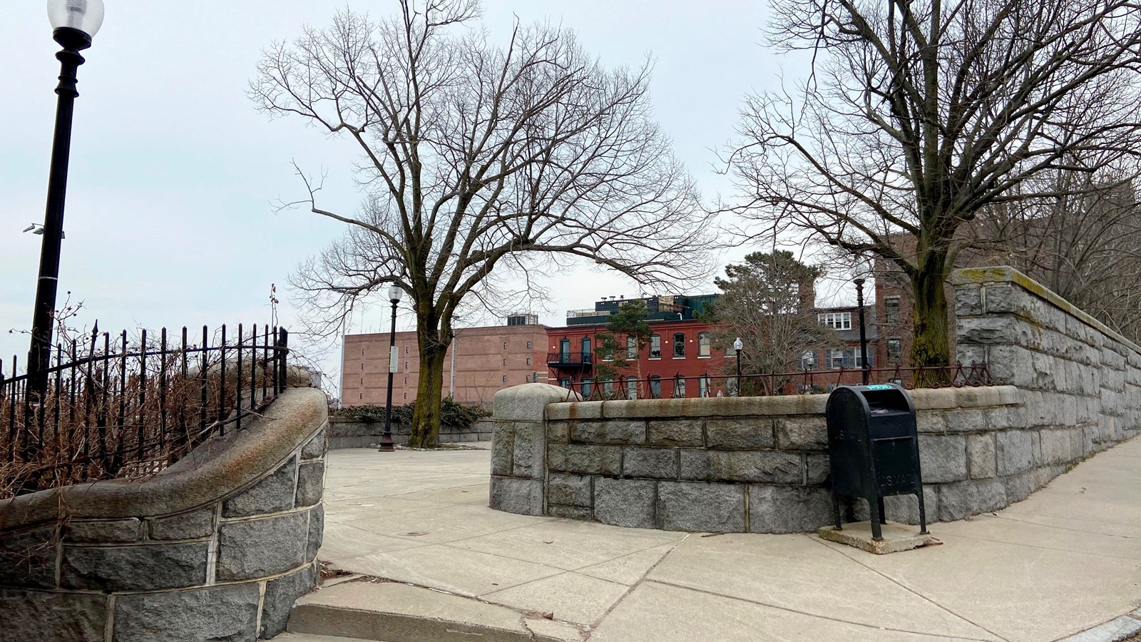 Entrance to a park area with a stone way on either side of the entrance. 