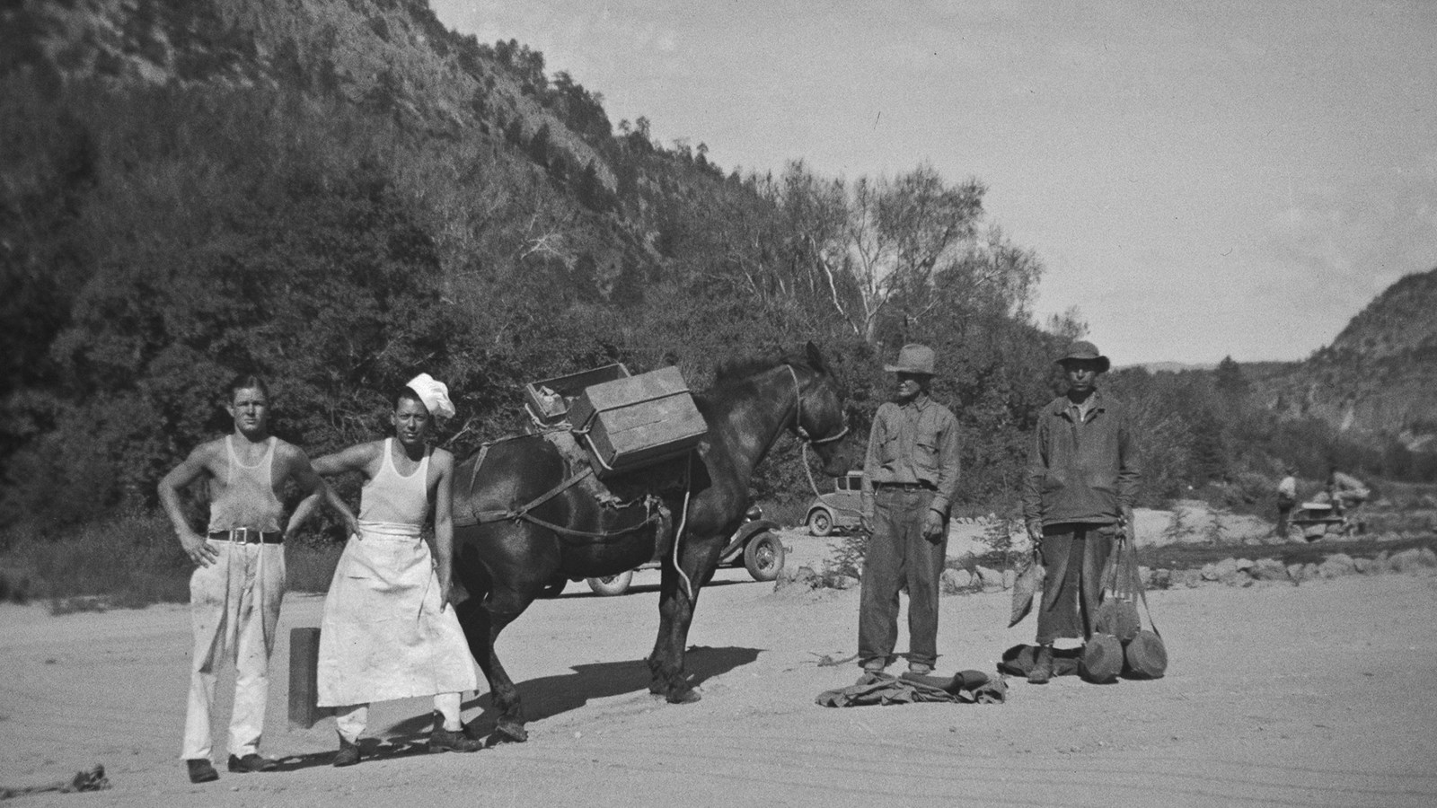 4 men in 1930s clothing stand with a horse 