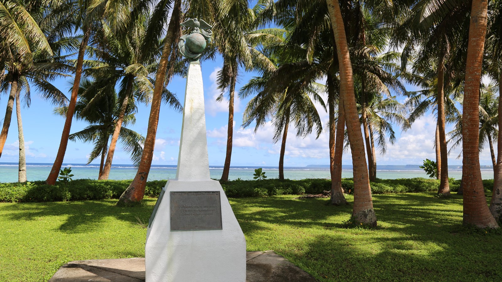 A white obelisk with a round ball with an eagle perched on it on the top.