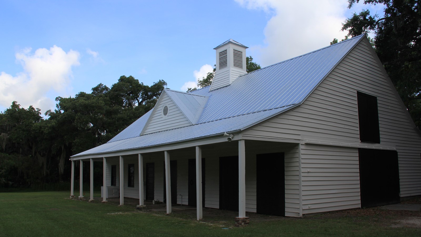 A two-story, seven-bay-by-three-bay, wood-frame, ten-stall barn painted white.  