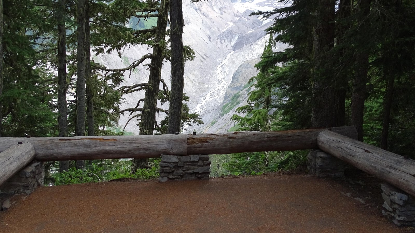 An overlook bordered on three sides by low log railings. Nisqually Glacier is in the distance.