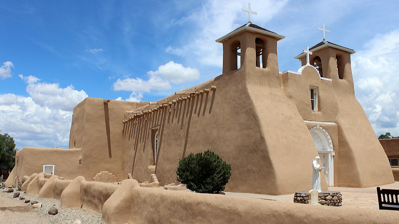 Smooth tan plaster church with two bell towers above the front door