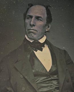 Balding middle-aged man in 1800s clothing. 