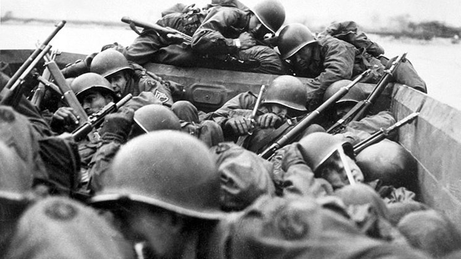 Uniformed men huddled in an open topped vehicle in the water