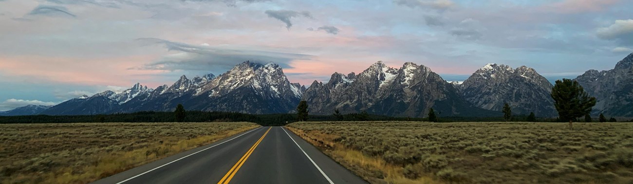 A road leading towards a mountain range.