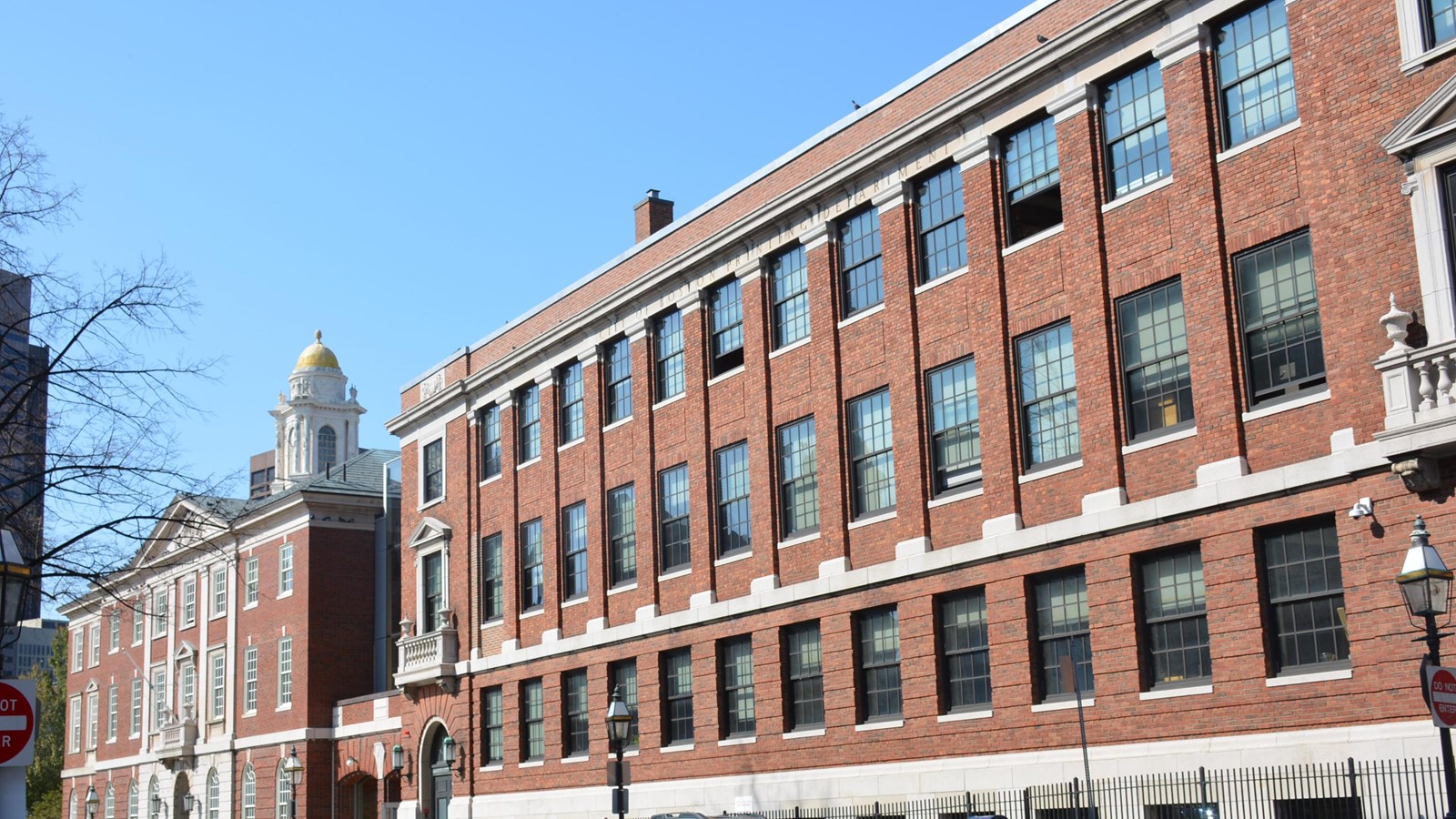 A red-brick 4-story building that\'s rectangular and has 12 windows on each floor.
