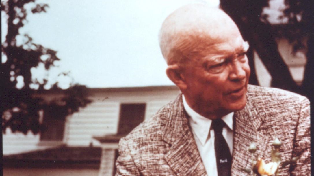 A color image of General Eisenhower  holding several roses in the rose garden near the home