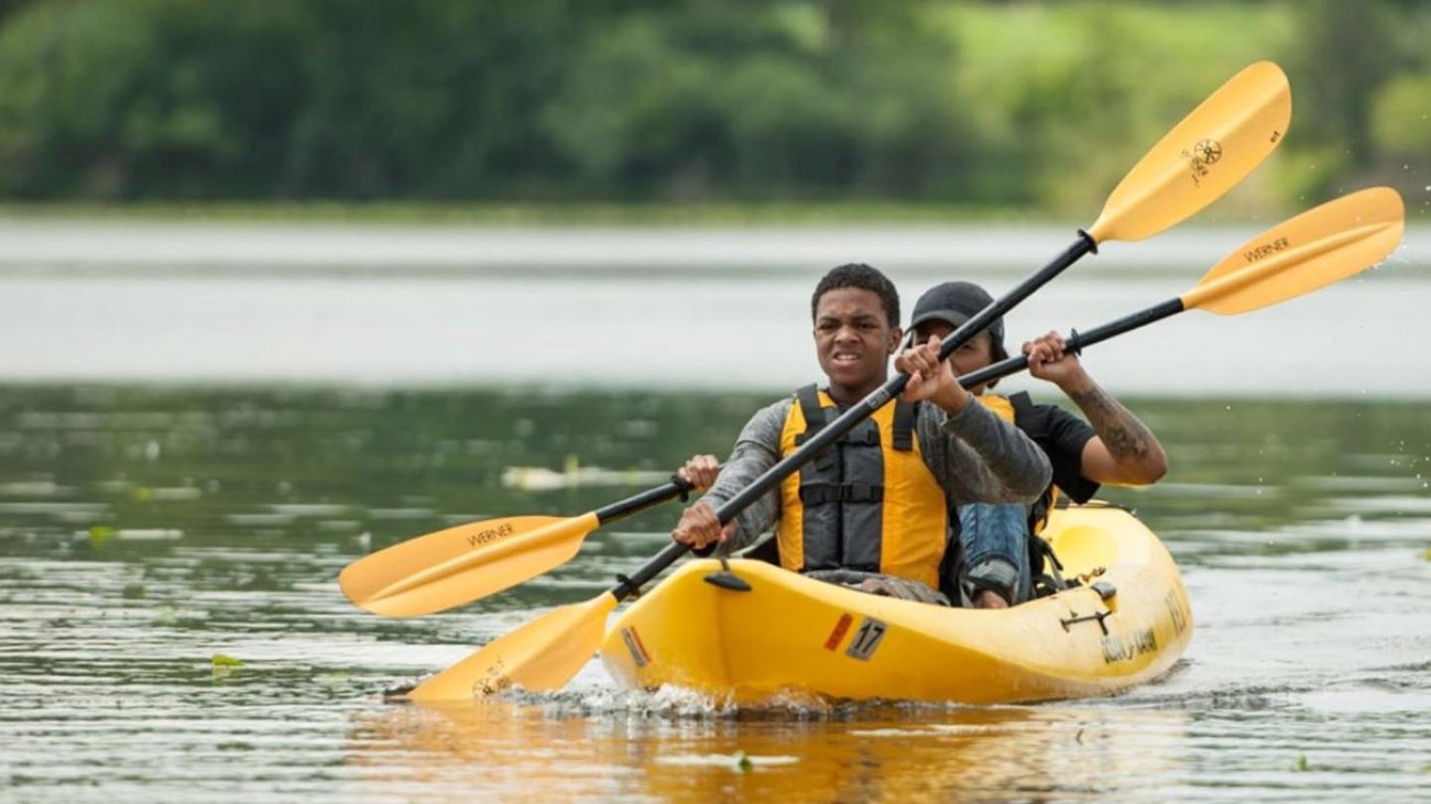 Two persons in a kayak on the river.  