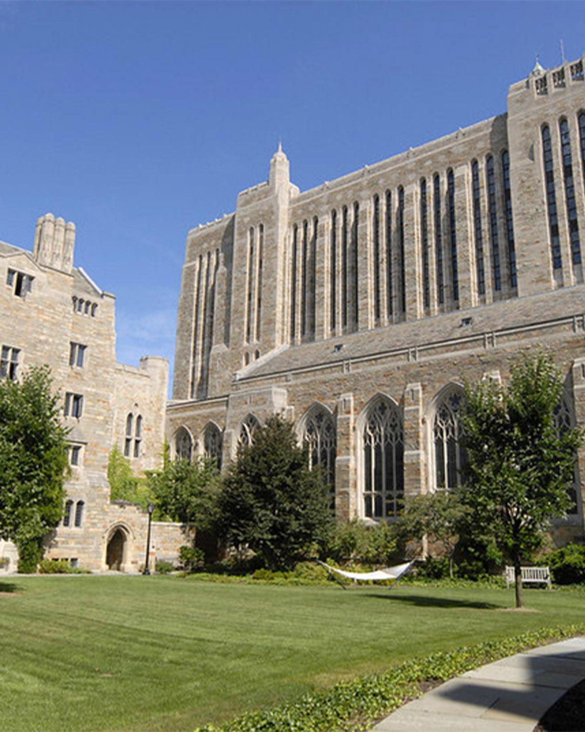 A large multi-story stone-and-brick building with an arched window and two towers.