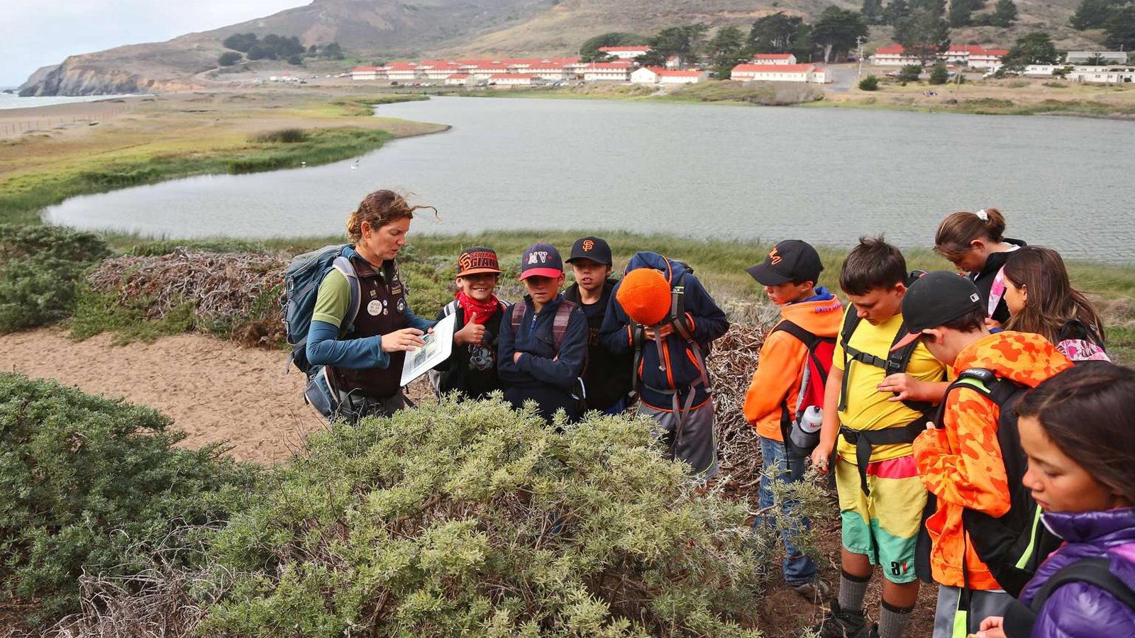 A group of young students on a hike with an instructor from NatureBridge overlooking Rodeo Lagoon.