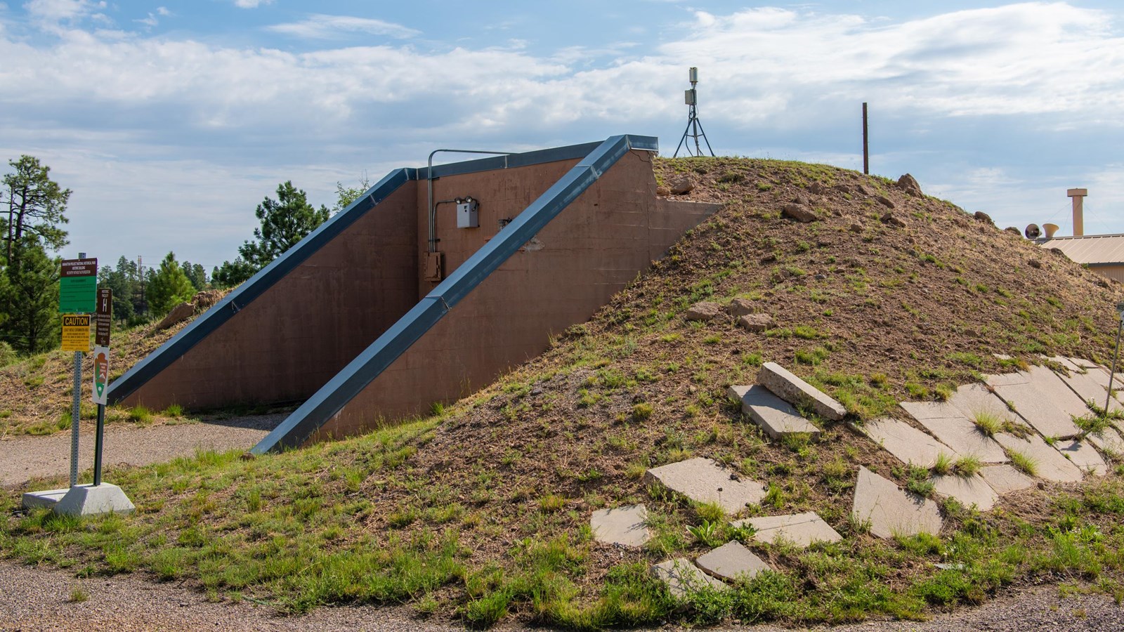 A red doorway set into a grassy berm.