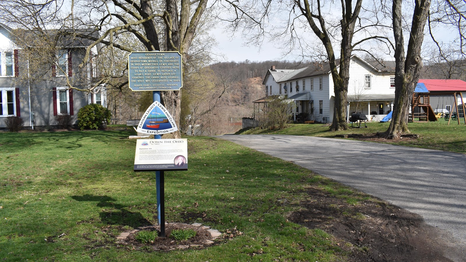 This photo captures a quiet residential street in Georgetown, Pennsylvania, with historical markers 