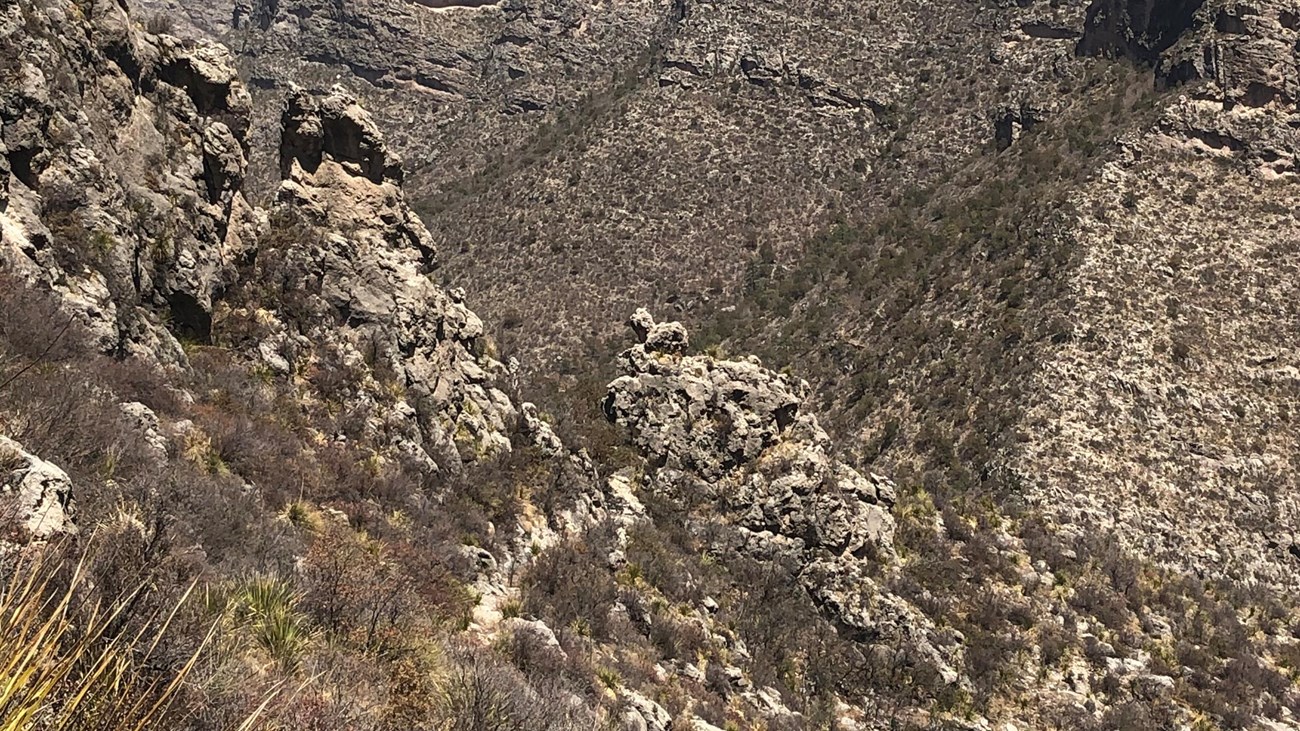 A trail runs through a small gap in a ridge
