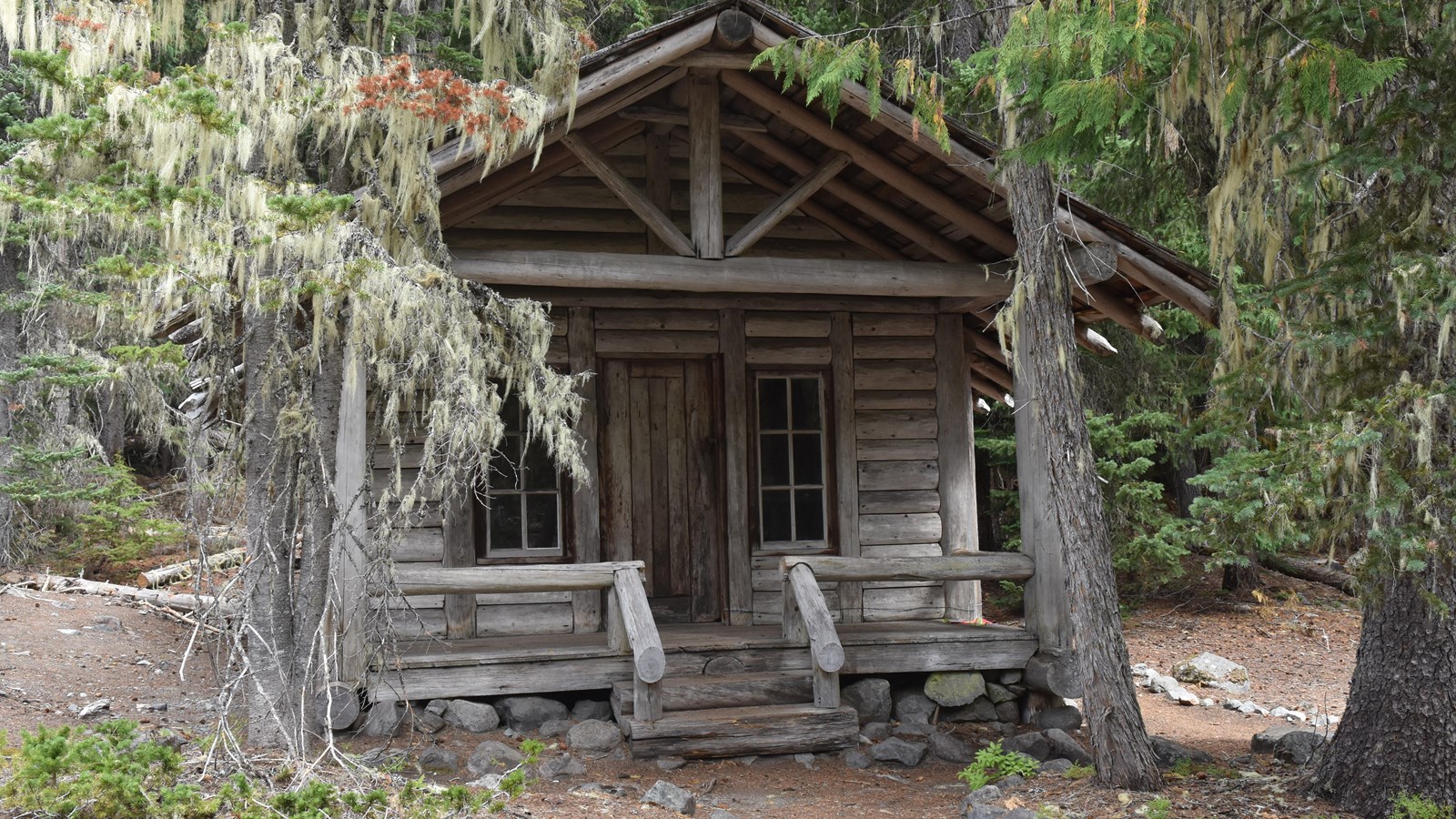 One story, three room rectangular building made up of wood and log posts with a beam frame